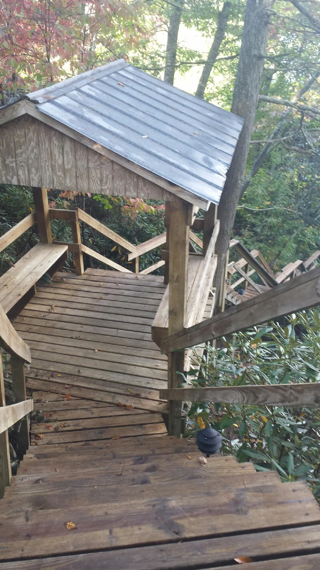 Metal roofed shelter over wooden steps on a wooded walkway — Skylight Repair & Installation work by our crew in Richfield